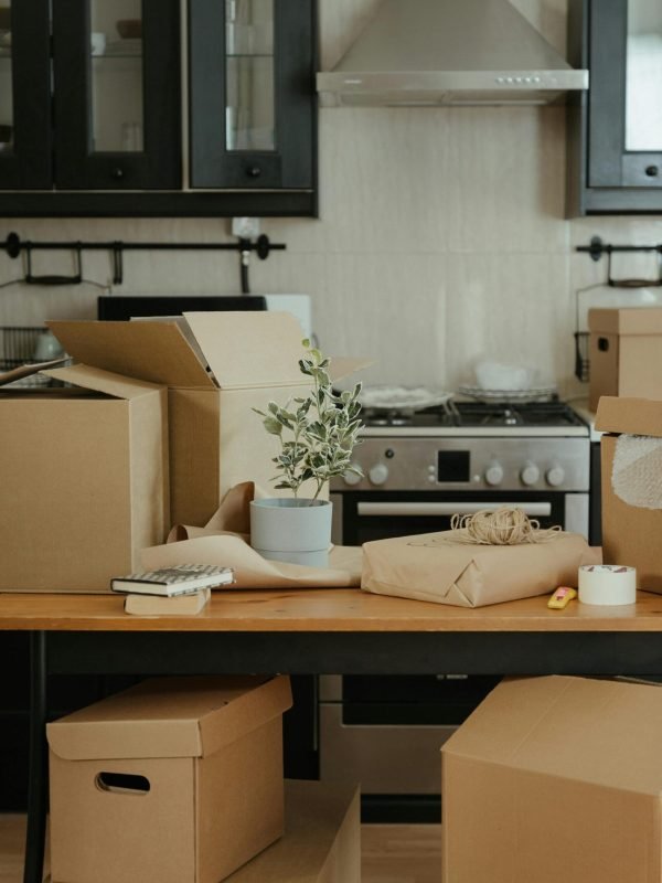 Cardboard moving boxes on a kitchen table during a home improvement and organization project.